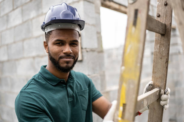 istock Portrait of a construction worker holding a ladder in a construction site 1352748815