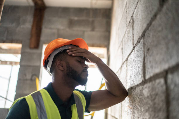 un ouvrier de la construction inquiet analyse un chantier de construction - tired men african descent sadness photos et images de collection