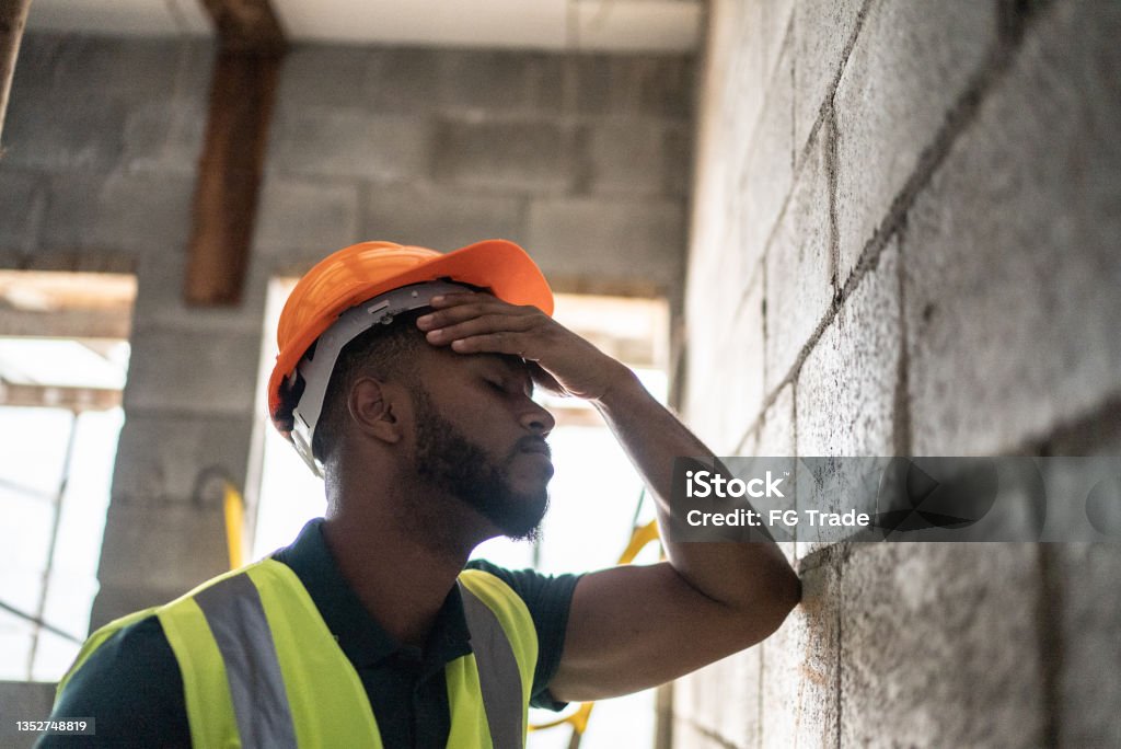 Worried construction worker analyzing construction site Construction Worker Stock Photo