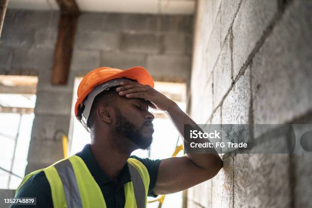 Worried Construction Worker Analyzing Construction Site Stock Photo - Download Image Now