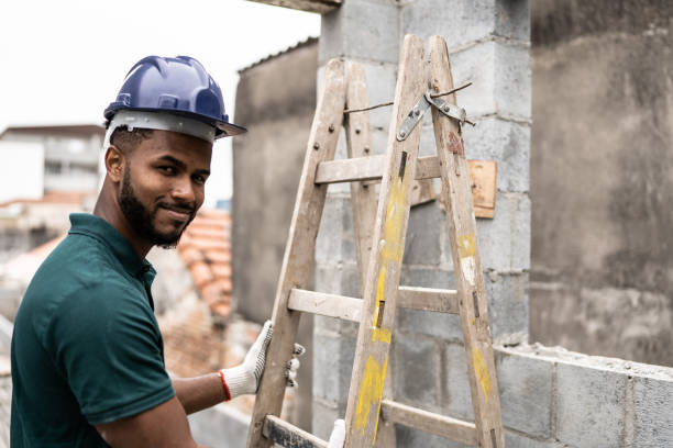 istock Portrait of a construction worker holding a ladder in a construction site 1352748832
