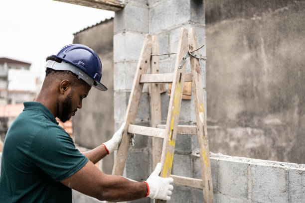 istock Young man arranging a ladder in a construction site 1352748845