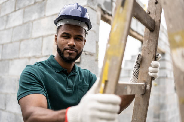 istock Portrait of a construction worker holding a ladder in a construction site 1352748865