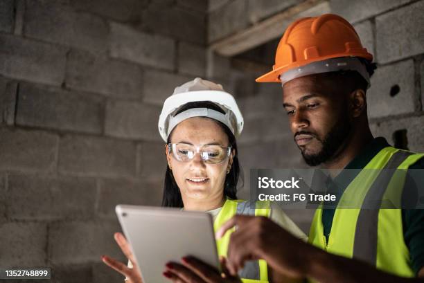 Construction site workers using digital tablet having a meeting