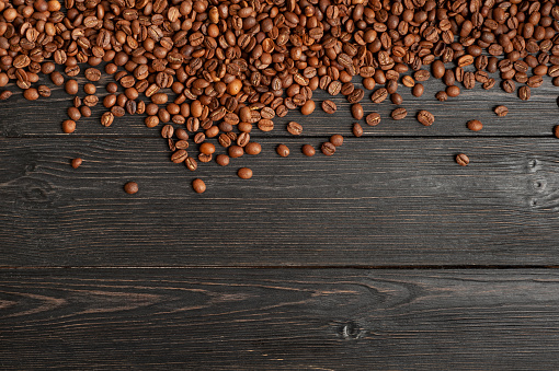 Coffee beans on old wooden dark planks background. High quality photo