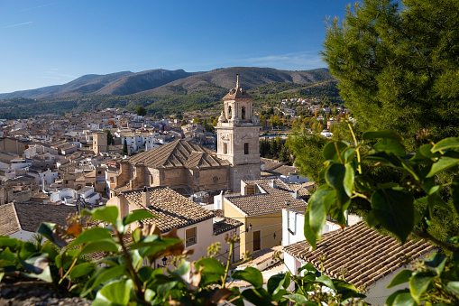 Caravaca, Spain - November 17, 2017: panorama of the city of Caravaca de la Cruz and conifers in the foreground, a place of pilgrimage near Murcia in Spain.