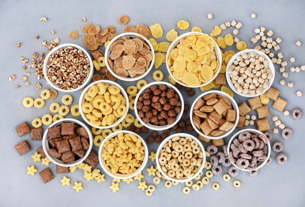 istock Various breakfast cereals on light grey background, assorted corn flakes in bowls 1352752925