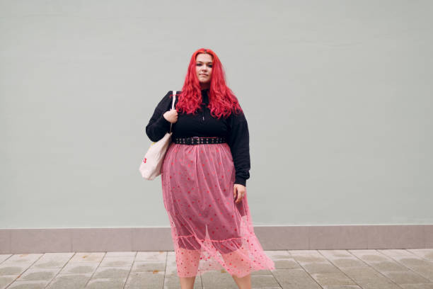 mujer lgbtq positiva con sobrepeso con sobrepeso y cuerpo positivo con cabello rojo y gafas rosas - teen obesity fotografías e imágenes de stock