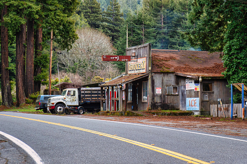 Garberville, United States - February 16 2020: two pick up trucks are parked next to a grocery or general store along the avenue of the giants
