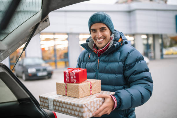 istock Smiling man loading car trunk with Christmas gifts during Christmas holidays. 1352767683