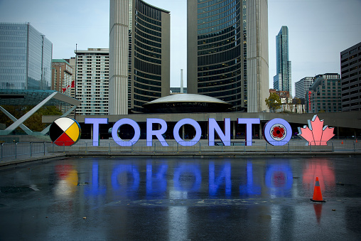 Toronto, Ontario, Canada- November, 11 2021: The Toronto sign at Toronto city hall's Nathan Phillips Square reflecting into the water and honouring the men and women who served in the Canadian armed forces.