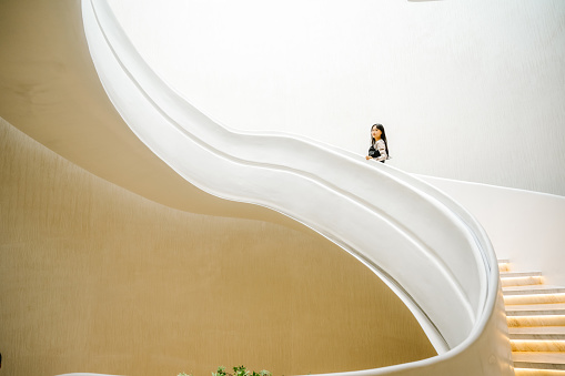 Women walking in empty clean and bright modern buildings spiral stairs