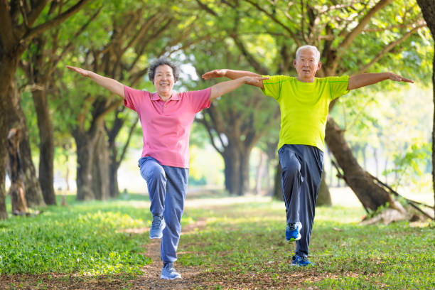happy senior couple exercising in the park - balance 個照片及圖片檔
