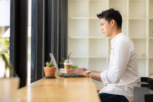 istock Young Asian men, future students for self or personal learning ideas. Online students at coffee shops with books and laptops. 1352774720