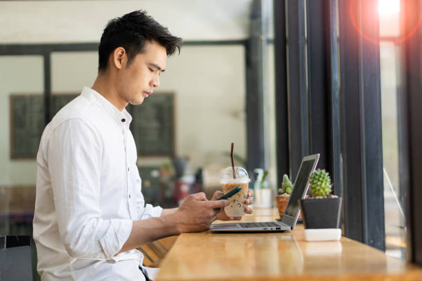 istock Young Asian men, future students for self or personal learning ideas. Online students at coffee shops with books and laptops. 1352774724