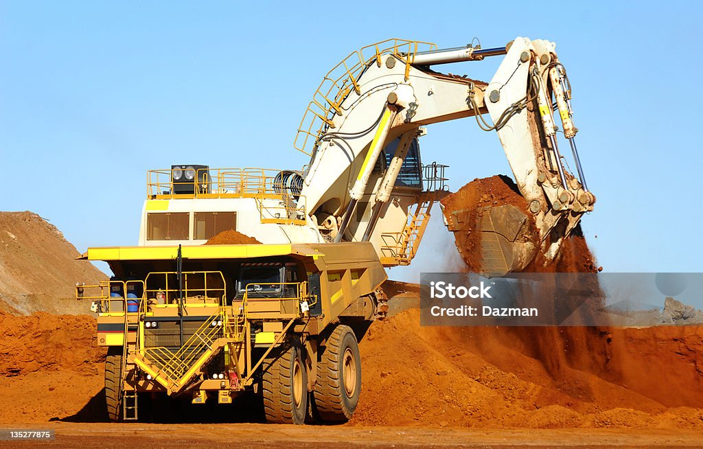 Excavator carregamento de minério metálico dentro de um carrinho de transporte. - Royalty-free Camião Foto de stock