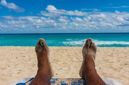 Male Feet covered in Sand on the Beach