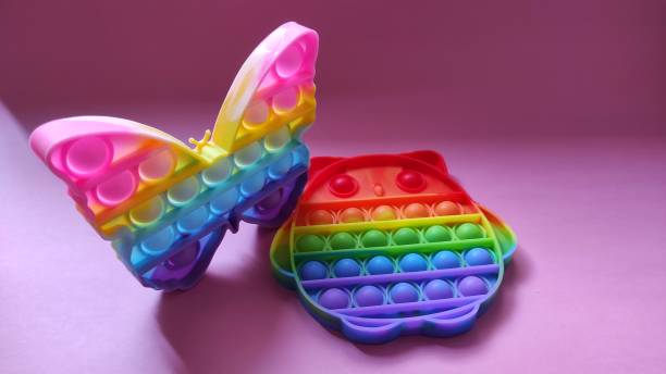istock Two rainbow colored Pop it toys on a pink background 1352782417