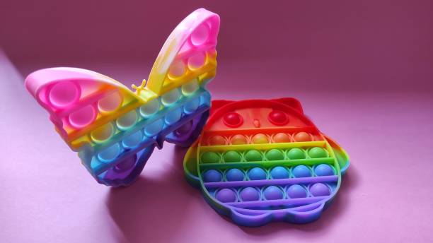 istock Two rainbow colored Pop it toys on a pink background 1352782426