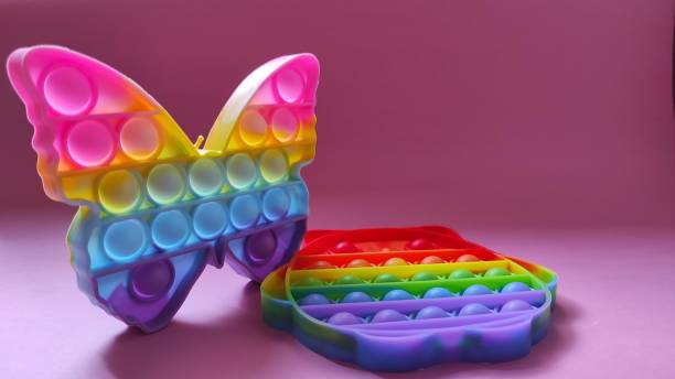 istock Two rainbow colored Pop it toys on a pink background 1352782434