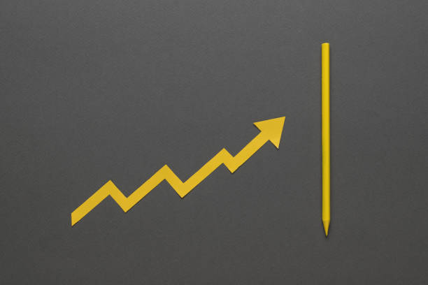 istock A curve growing upwards, resting on a yellow pencil on a gray background. 1352783382