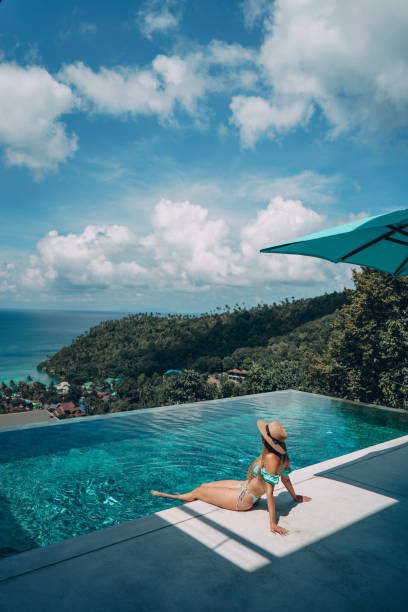 istock Attractive woman enjoying at poolside 1352785277