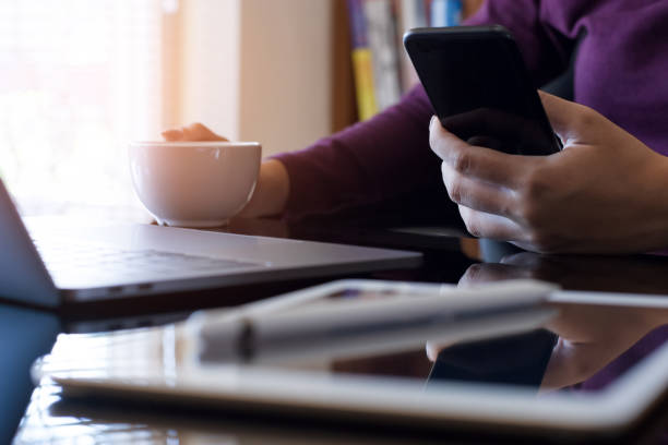 istock business woman using mobile smart phone while drinking coffee 1352793419