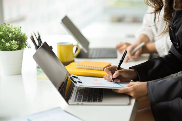 istock Side view, Business people in accounting team working on laptop computer 1352795862