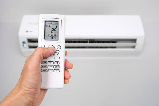 istock Man's hand using remote control open The air conditioner is cooled to 25 degrees Celsius in his bedroom. Health concepts and energy savings. 1352797487