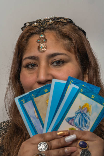 woman wearing make up and jewelry showing tarot cards - magic magic trick vertical tarot cards imagens e fotografias de stock