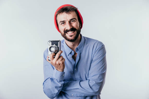 In this image we see a freelancer smiling with an old camera