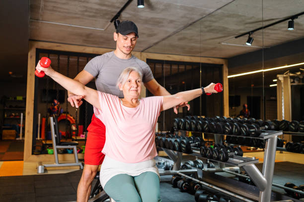 istock fitness instructor helping senior woman 1352803388
