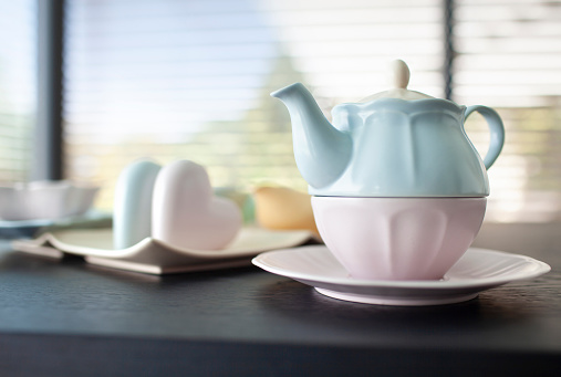 Woman hand's holding teapot with tea cups on table, Tea ceremony concept