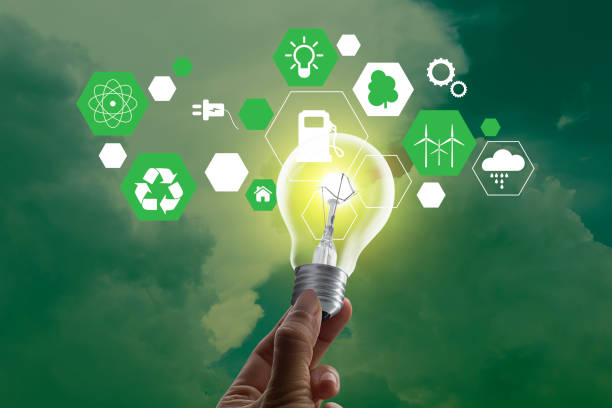 istock Hold lamp with energy resources icon and cloudy sky green background. Energy saving concept 1352803600