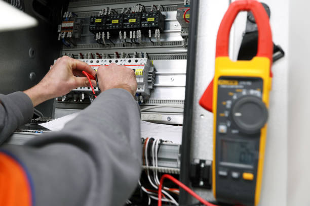 istock Electrician is measuring voltage of switchgear with clamp meter. it is composed of electrical disconnect switches, fuses or circuit breakers used to control, protect and isolate electrical equipment. 1352806708