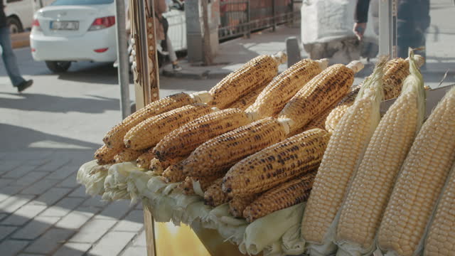 Street Food Vendor with Delicious Grilled, Cooked and Steamed Yellow Corns Served and Ready to Eat on Stall