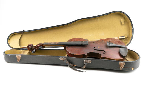 istock Wide closeup studio shot of old, broken, dust covered violin with its old, scratched case, isolated on white background. Vintage damaged musical instrument. Concept for restoration. 1352810968