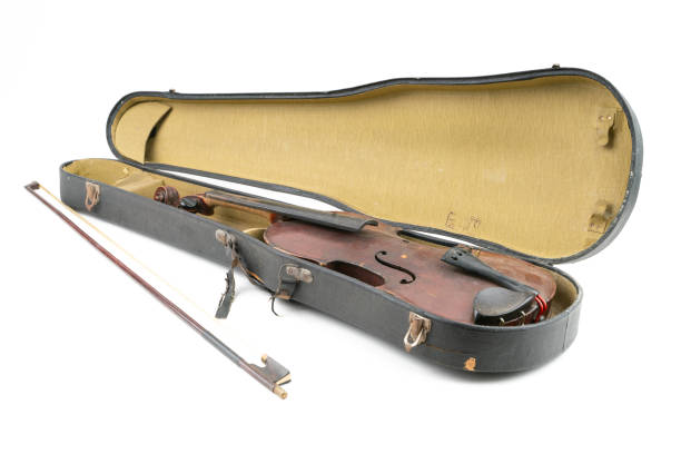 istock Wide closeup studio shot of old, broken, dust covered violin with its old, scratched case, isolated on white background. Vintage damaged musical instrument. Concept for restoration. 1352810972