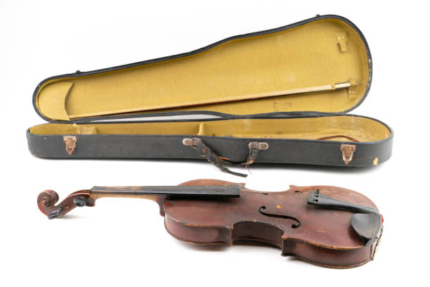 istock Wide closeup studio shot of old, broken, dust covered violin with its old, scratched case, isolated on white background. Vintage damaged musical instrument. Concept for restoration. 1352810978