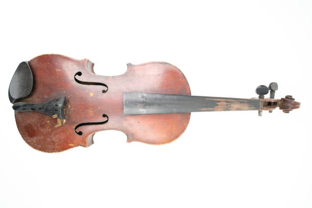 istock Wide closeup studio shot of old, broken, dust covered violin isolated on white background. Vintage damaged musical instrument. Concept for restoration. 1352810981