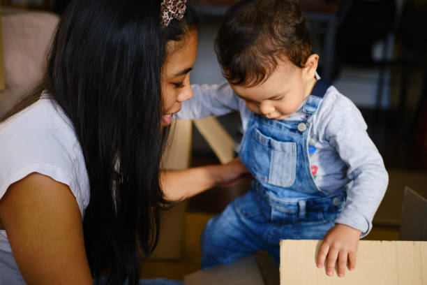 istock A young mother playing with her son with a cardboard box. 1352811735