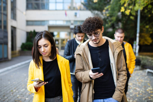 istock Young people looking at smartphones 1352811882