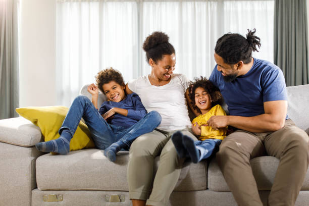 istock Happy black family having fun on sofa at home. 1352812044
