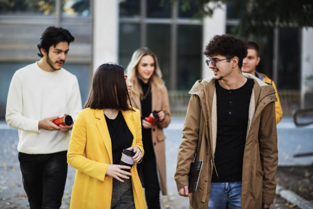 istock Happy college students walking together on campus 1352814003