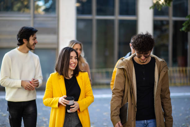 istock Happy college students walking together on campus 1352815089
