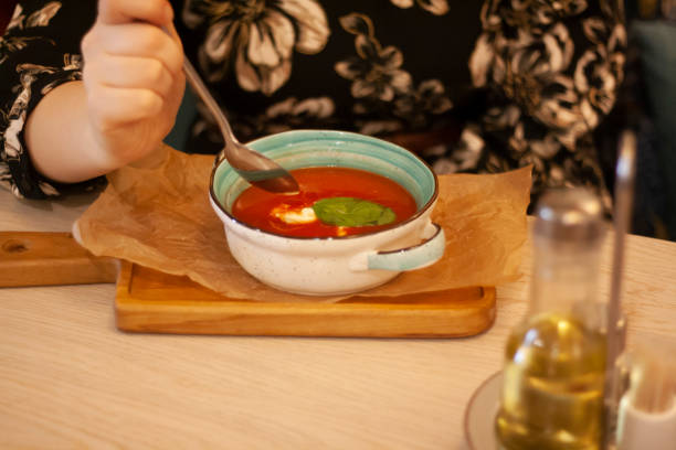 istock A woman is eating tomato soup with a spoon 1352815505