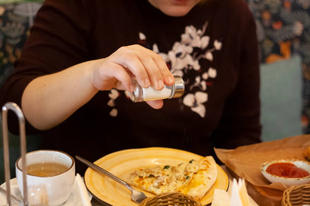 istock A woman salts pizza 1352815524
