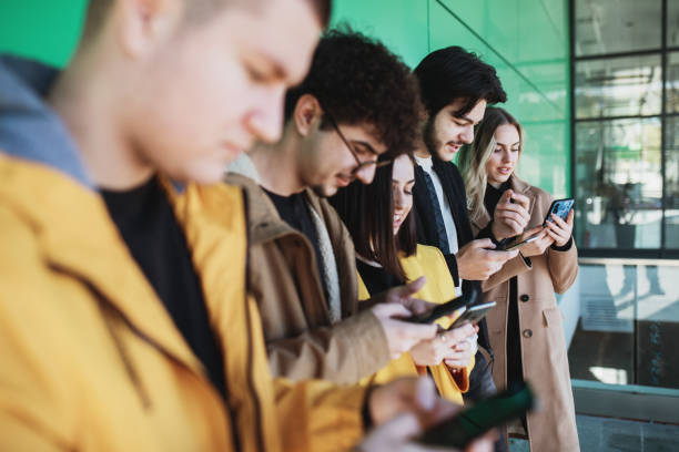 istock Young people looking at smartphones 1352815570