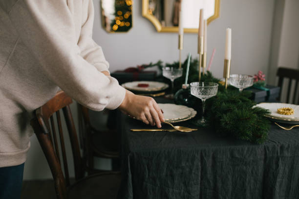 istock Young woman serving Christmas table with beautiful festive tableware. Preparations for holiday dinner. 1352816473