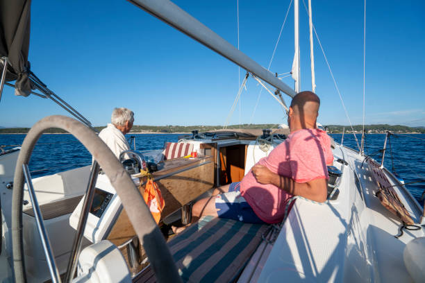 istock A men on a sailboat looking at islands while sailing, Croatia 1352816650